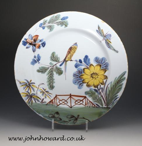 Bristol delftware pottery charger with a yellow bird perched in foliage 18th century