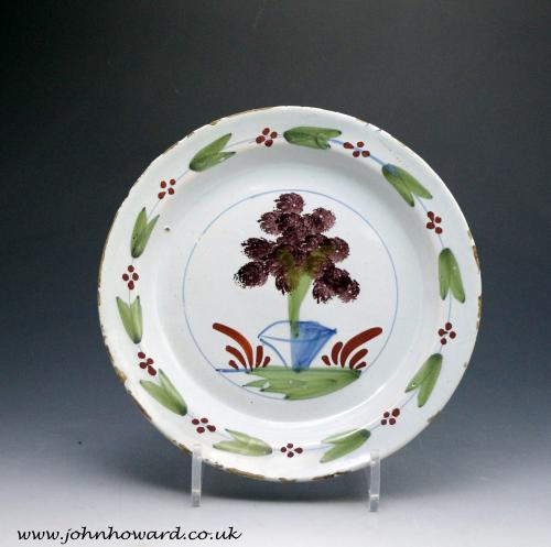 Antique English delftware polychrome decorated plate of a shrub in a pot London mid 18th century