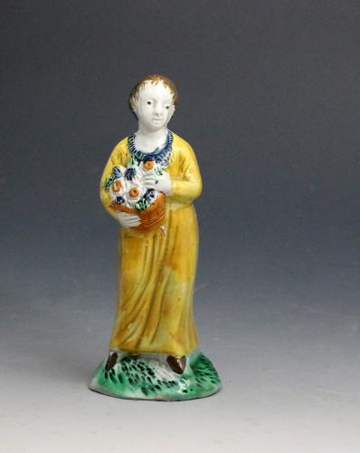 Staffordshire pottery figure of a girl holding a basket of flowers late 18th century