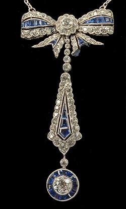 Platinum set Art Deco calibre natural sapphires and diamonds in bow pendant form, circa 1920