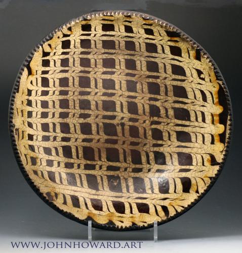 English slipware earthenware circular baking dish profusely decorated with an elaborate lattice pattern