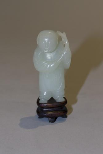 A pale celadon jade carving of a standing boy holding a branch, Qianlong, 1736-1795