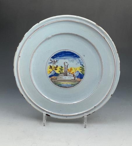 Italian pottery faience plate with painting of a church near mountains circa 1700