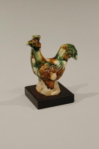 A Chinese sancai (three colour) small pottery model of a standing cockerel, Tang dynasty, 618-906