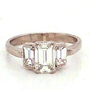 Platinum set three stone emerald cut diamond ring