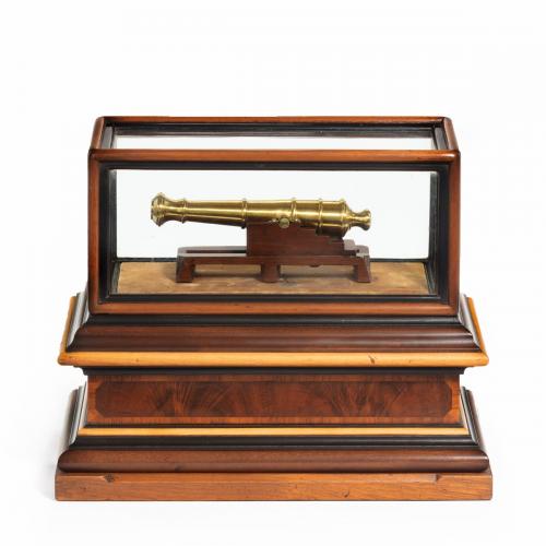 A miniature brass cannon in a presentation case