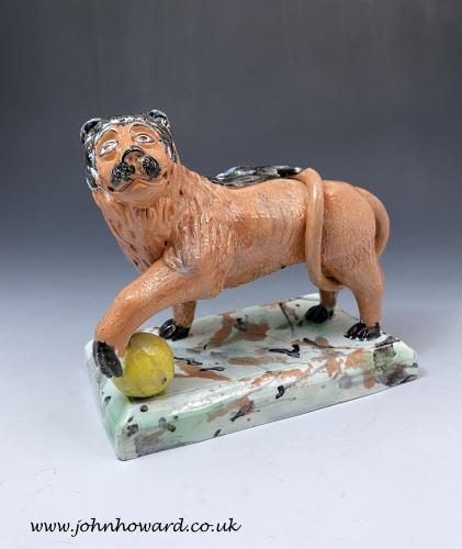 Staffordshire pottery pearlware figure of a lion on a faux marble base early 19th century