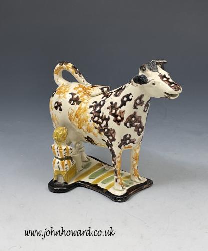Pottery figure of a cow and milkmaid in the form of a creamer English circa 1810