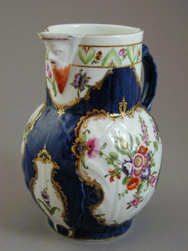 Worcester scale blue ground mask jug decorated with floral panels, c.1775