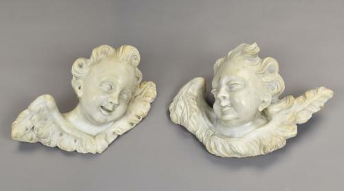 A pair of carved white marble reliefs of cherubs, c.1700