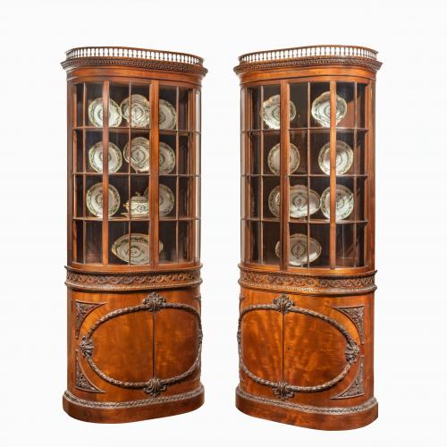 A pair of mahogany shaped display cabinets attributed to Gillows