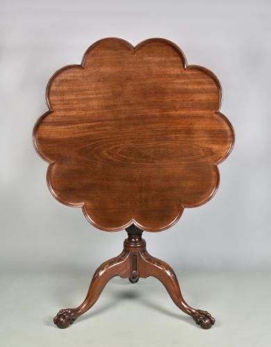 An unusual George III mahogany tripod table with shaped dished top and a pierced claw and ball foot, c.1760