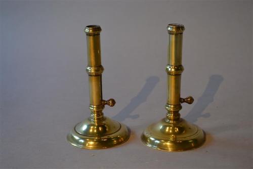 A pair of George II brass ejector candlesticks