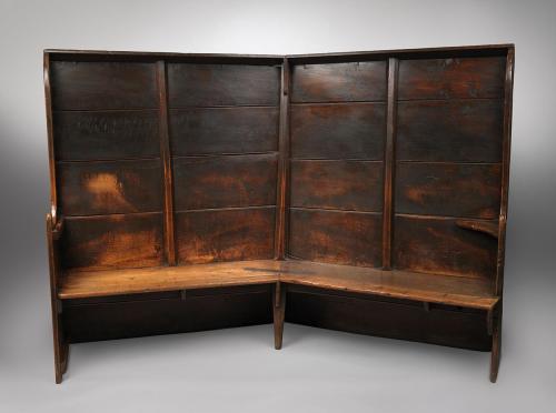 Remarkable Georgian Tavern Settle Of Angled Form with Shallow Canopy and Shaped Board Arms Solid Elm with Richly Patinated Surface English, West Country, c.1780