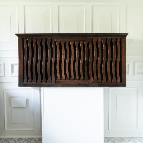 A 17th century oak wall cupboard with slatted front