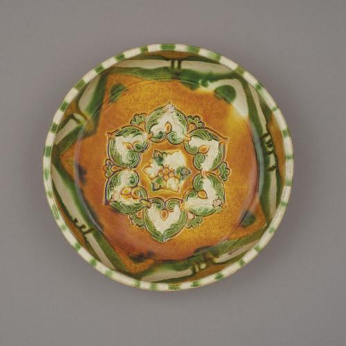 Chinese sancai, three-colour glazed pottery basin, pen, moulded in the centre with a six-petalled flowerhead, Tang dynasty, Gongxian kilns, 7th – 8th century.