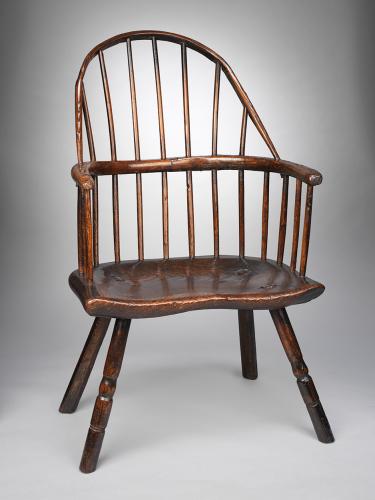 A Rare Primitive Bow Back Windsor Armchair With "Shawled" Back Bow above Horseshoe Arm and Broad Saddled Seat Richly Patinated Ash and Elm, with Traces of Historic Paint English, West Country, c.1780