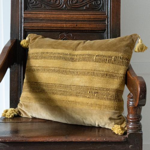 A cushion of 19th century naturally dyed flatweave, velvet and linen