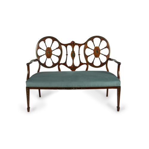 A late Victorian satinwood wheel back settee in the Chippendale style, attributed to Wright and Mansfield