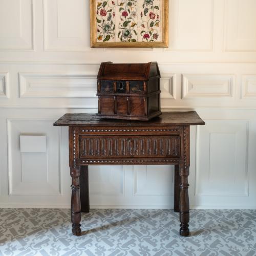A room with an Elizabethan oak table, an elizabethan oak table cabinet and an early 18th framed crewelwork panel