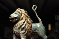 17TH CENTURY CARVED AND POLYCHROMED LIMEWOOD SCULPTURE OF A LION PASSANT.