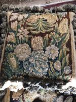 A rare set of eight, mid-17th century, verdure tapestry cushions with custom-made passmenterie