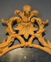  A George III carved oval ochre painted pine mirror