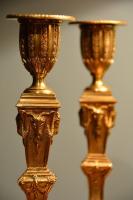  A fine pair of neo-classical ormulu candlesticks decorated overall with neo-classical motifs.