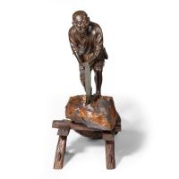 An attractive Meiji period bronze of a woodcutter sawing a large tree trunk