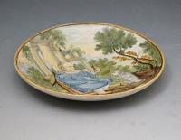 Italian pottery dish with figure offering a morsel to a dog 17th century