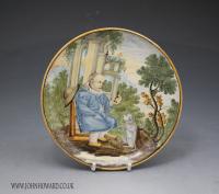 Italian pottery dish with figure offering a morsel to a dog 17th century