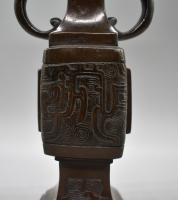A slender double-looped bronze vase