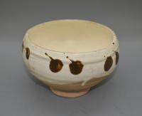 A white glazed bowl with russet-brown splashes