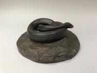 American bronze sculpture of a snake coiled upon a rock