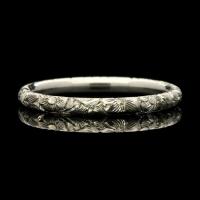 A prettily patterned platinum wedding ring with Georgian style floral engraving
