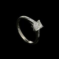A charming 0.71ct emerald-cut diamond and platinum ring with carre-cut diamond shoulders