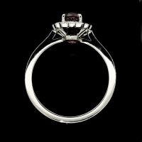 A classic oval ruby and round brilliant diamond cluster ring set in platinum