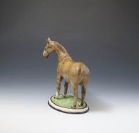 Pottery figure of a horse standing on an oval shaped base made England circa 1800