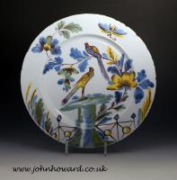 A pair of Delftware pottery charger from the Bristol Delftworks of two birds in a garden setting 18th century England