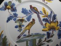 A pair of Delftware pottery charger from the Bristol Delftworks of two birds in a garden setting 18th century England