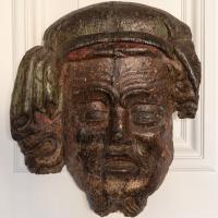 A rare Henry IV oak polychromed appliqué or mount, designed as a male mask, circa 1410