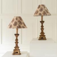 A pair of early 19th century carved giltwood candlesticks, converted to table lamps, with 19th century chintz shades