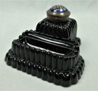 A rare opaque black glass ink and pen stand with gilded blue glass finial, Diamond Registration mark 1874 or 1876