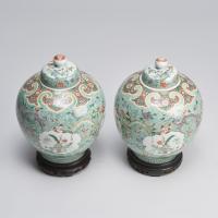 A finely painted pair of Chinese 19th Century famille verte jars and covers