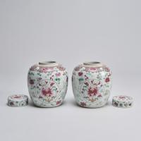 An ornate pair of 19th Century Chinese famille rose jars and covers