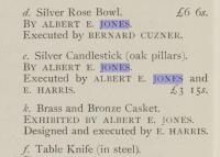 An exceptional near pair of A E Jones arts and crafts silver Ruskin set candlesticks