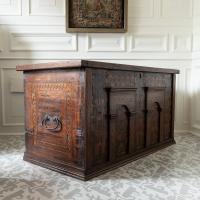 A large antique oak chest with architectural details and inlay, view of iron handle on one end