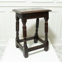 A dark oak antique four legged stool