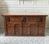 A large antique oak chest with architectural details and inlay, front view