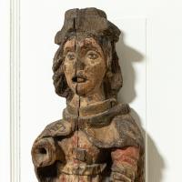 A close up of the top half of a 16th century carved figure